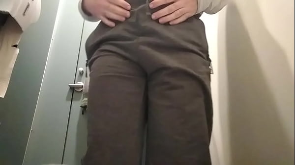 Młody gej sikający w publicznej toalecie