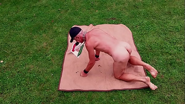 nagi, nieobcięty, zdemaskowany męski niewolnik wystawiony w klatce na penisa na zewnątrz rozciąga swoją gejowską cipę przed gośćmi imprezy BDSM CBT